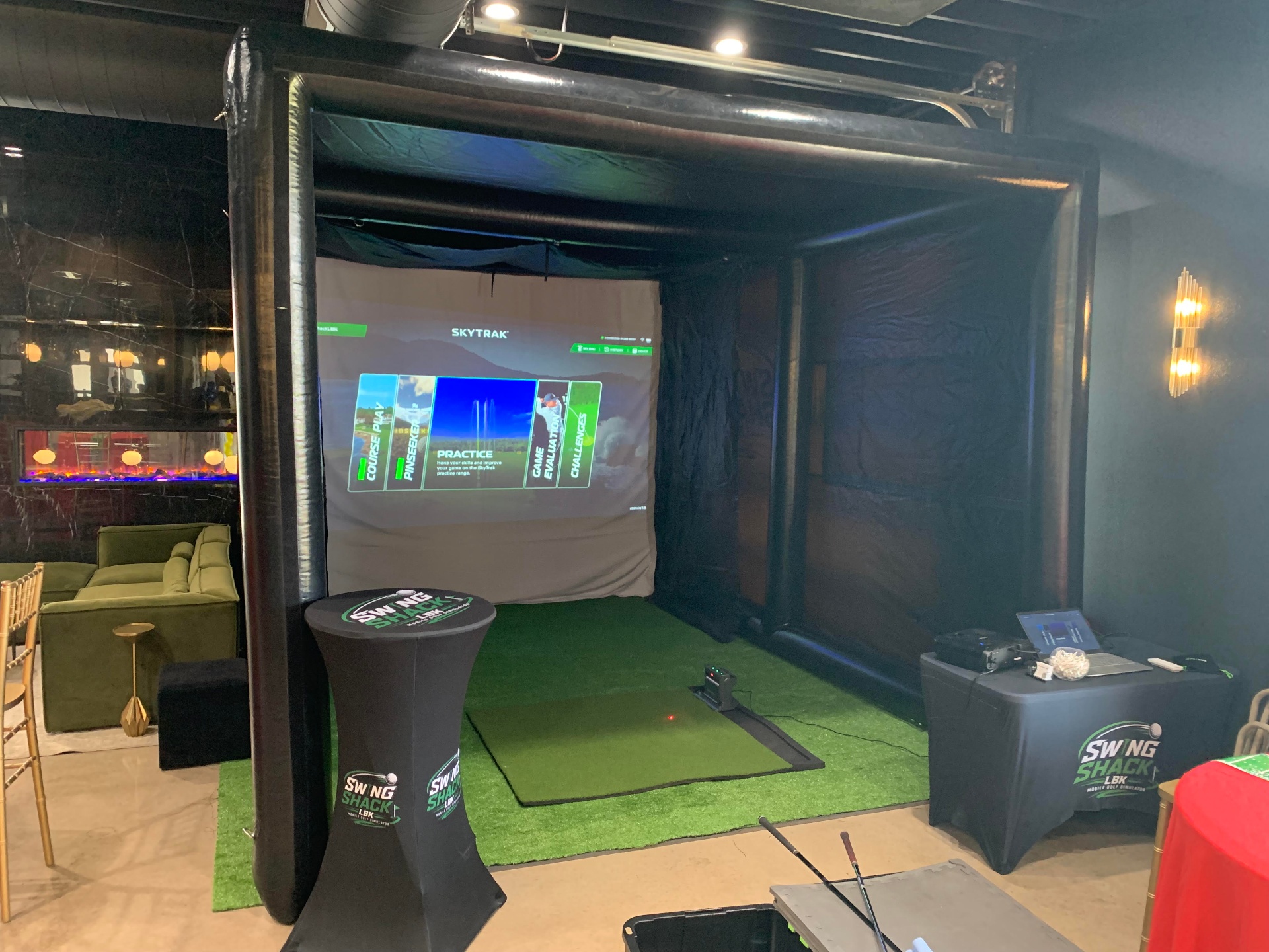 Swing Shack LBK inflatable mobile golf simulator setup with SkyTrak launch monitor, projector screen and turf